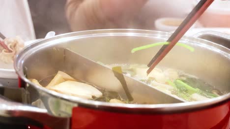 preparing hotpot soup with fresh ingredients