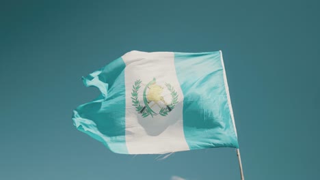 Guatemalan-white-and-blue-flag-waving-in-slow-motion-during-blue-sunny-day