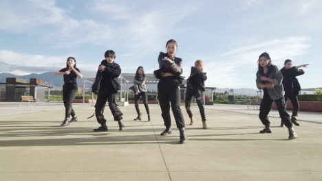 young street performer performing on the street. seven chinese teenagers dancing kpop