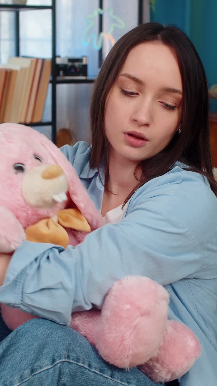 Woman on sofa hugging plush bunny feeling lonely romantic missing beloved tenderness divorce
