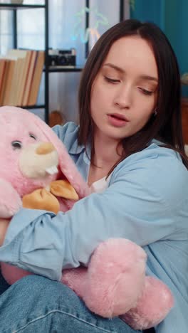 woman on sofa hugging plush bunny feeling lonely romantic missing beloved tenderness divorce