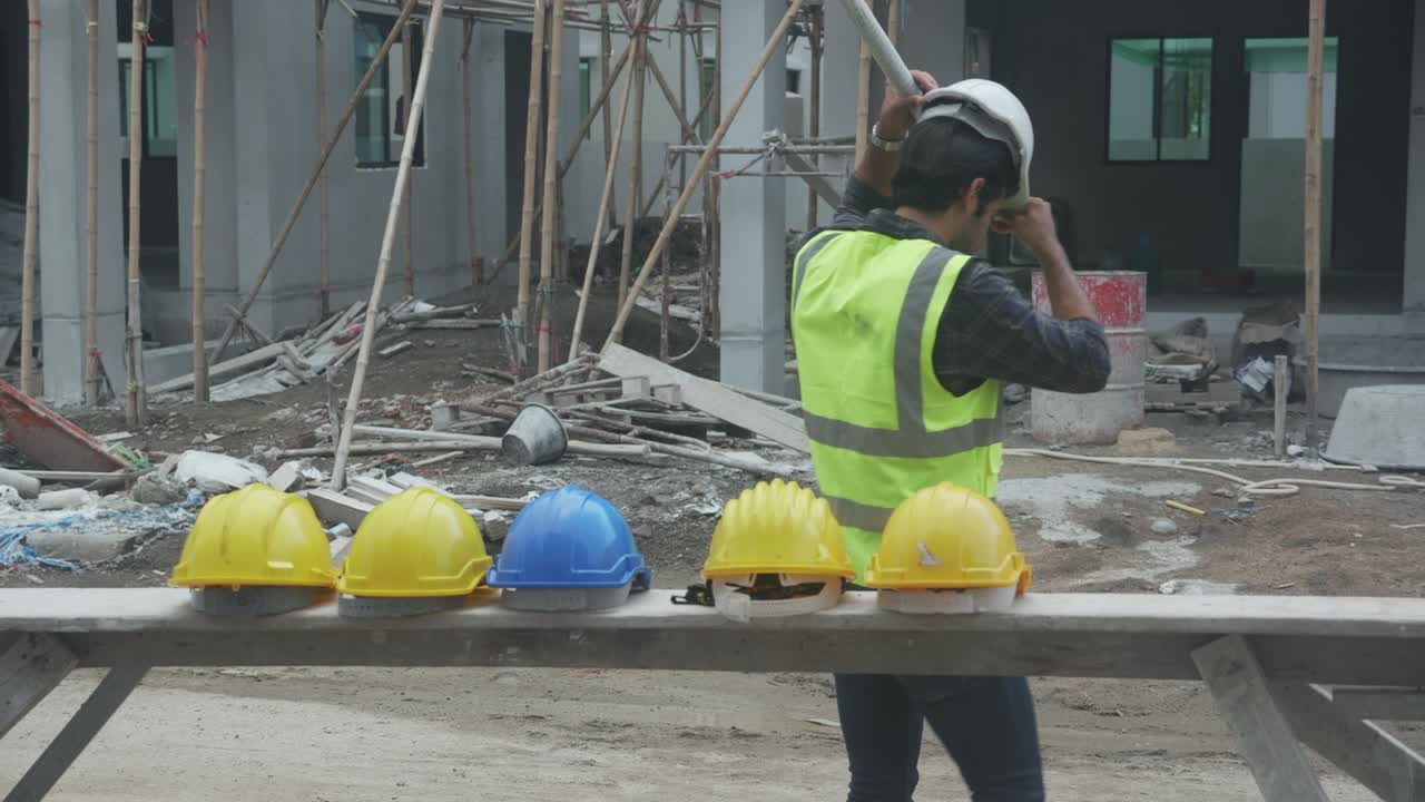 grupo de jóvenes contratistas asiáticos y trabajadores con sombrero duro caminando hacia el sitio de construcción con profesionales, arquitectos y trabajadores, constructores y trabajo en equipo, ingenieros y colegas con amistad.