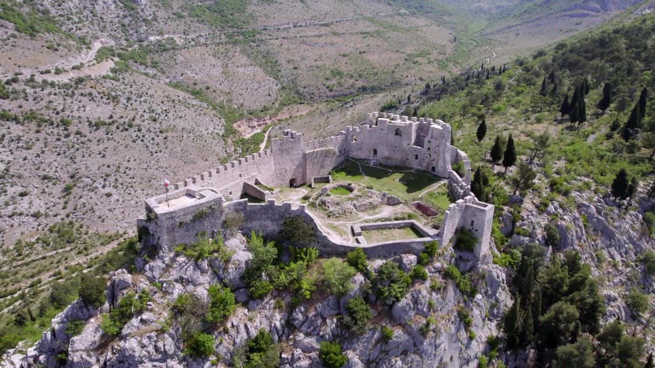 Le rovine della Fortezza di Blagaj occupano un'aspra cresta calcarea in Bosnia ed Erzegovina, ripresa aerea con orbita media a sinistra che rivela la posizione difensiva