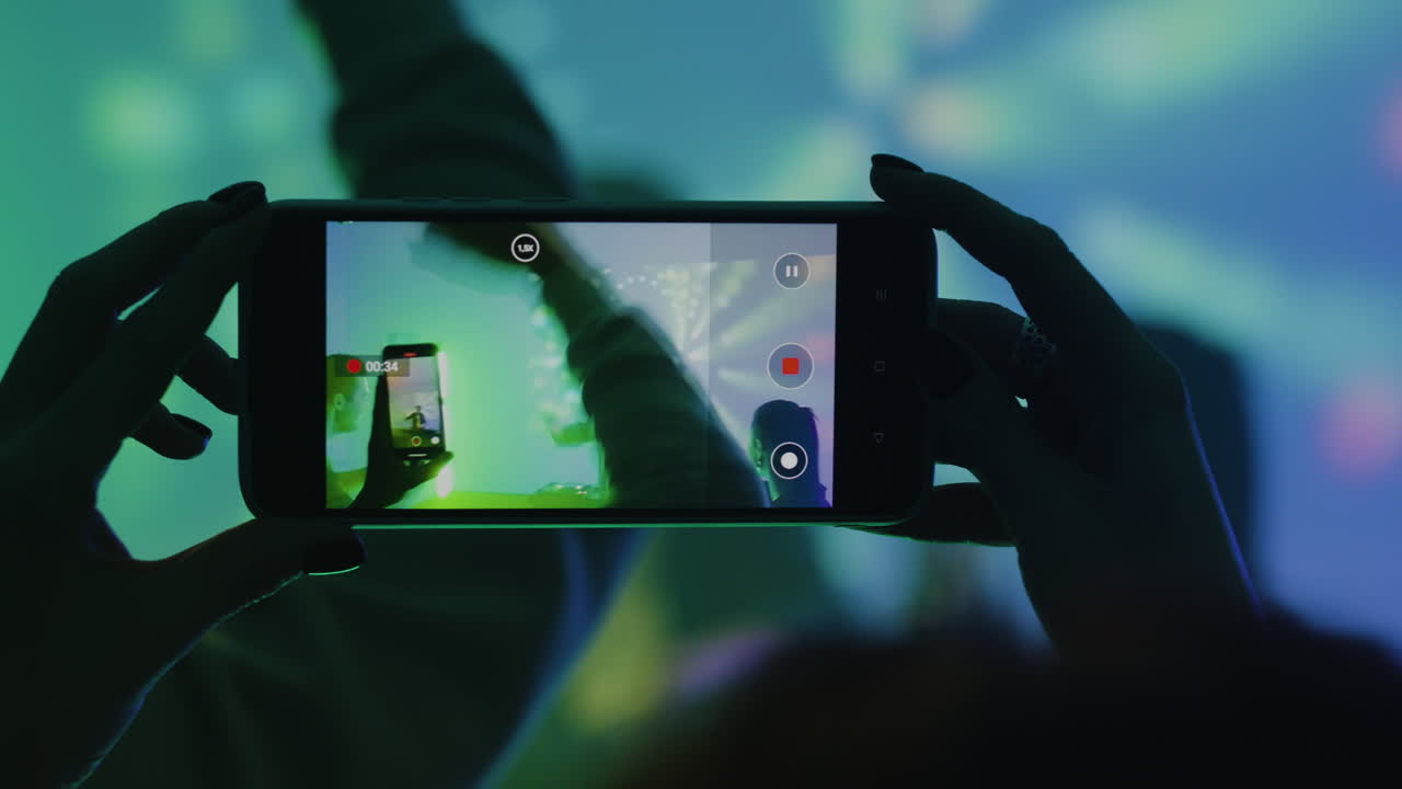 persona que utiliza un teléfono inteligente en la discoteca