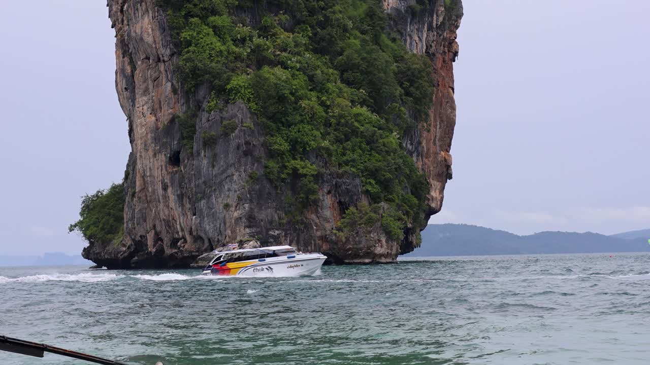 스피드 보트 는 높은 바위 형성 을 지나간다