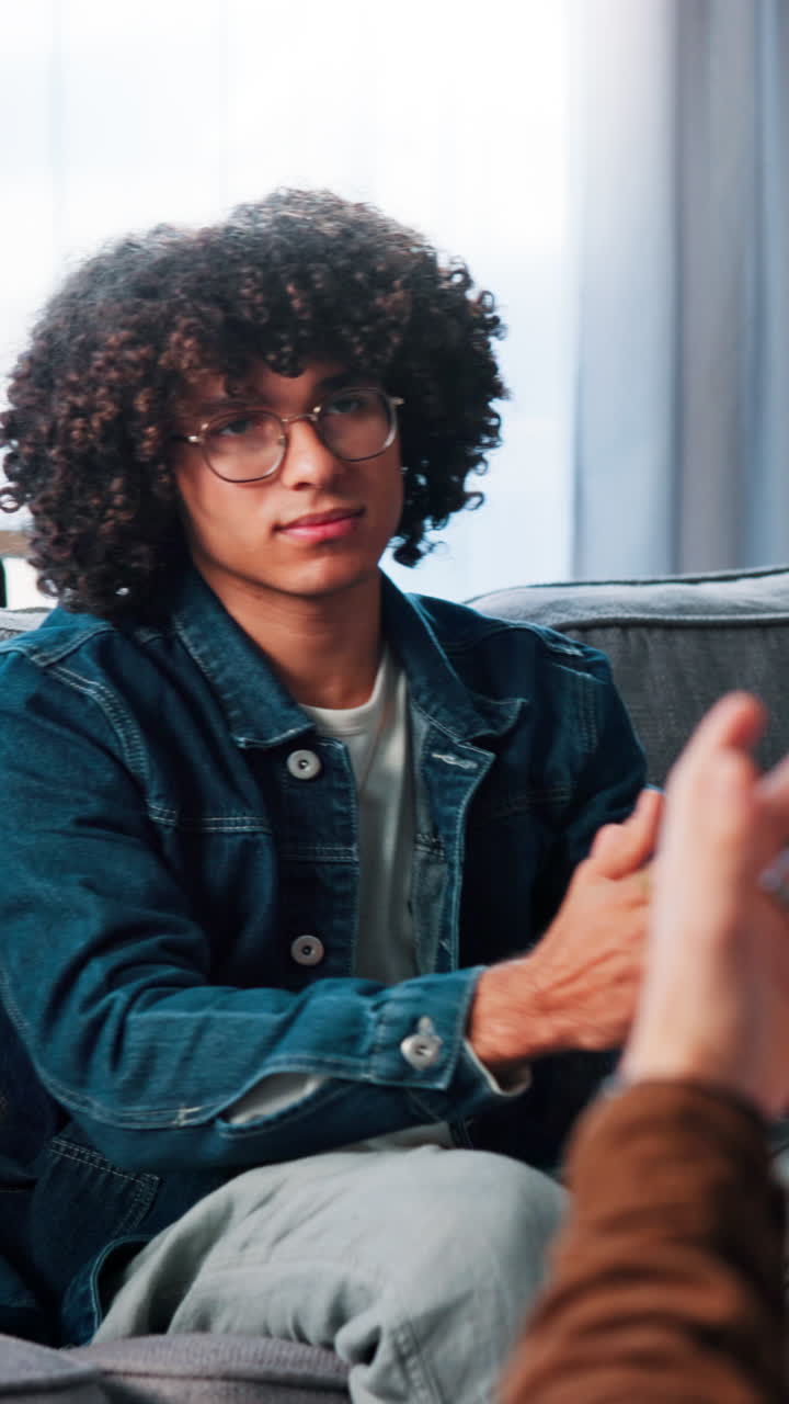 Portrait of a man with curly hair and glasses