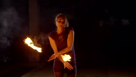 yong woman artist performing fire show at dark in slow motion.
