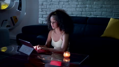 joven latina escribiendo un mensaje en su portátil por la noche