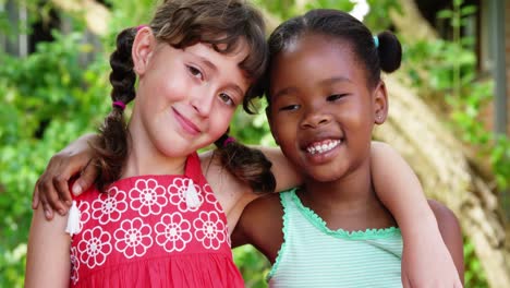 Portrait-of-school-girls-with-arms-around-in-campus-at-school