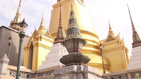 looking up at towering detailed golden pagoda spires in a buddhist temple complex in the rattanakosin old town of bangkok, thailand