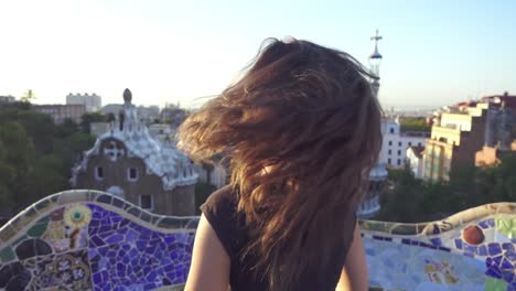 beautiful tourist walking in park guell. happy girl spiniing and smiling