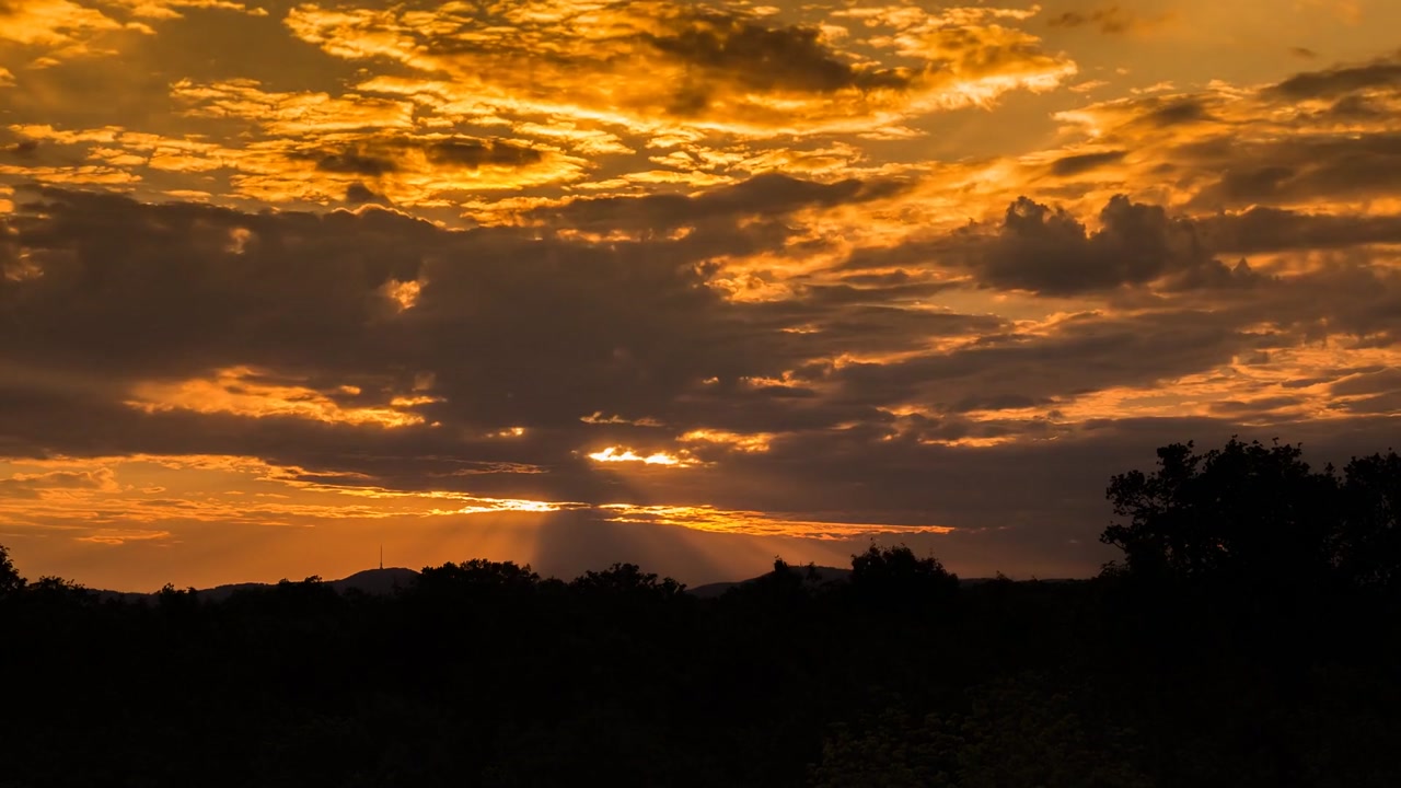 Sunset cloudscape time lapse sky vibrant orange yellow hues sunlight reflecting off clouds
