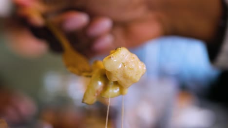 vista de cerca de una mano recogiendo deliciosos macarrones con queso con un tenedor