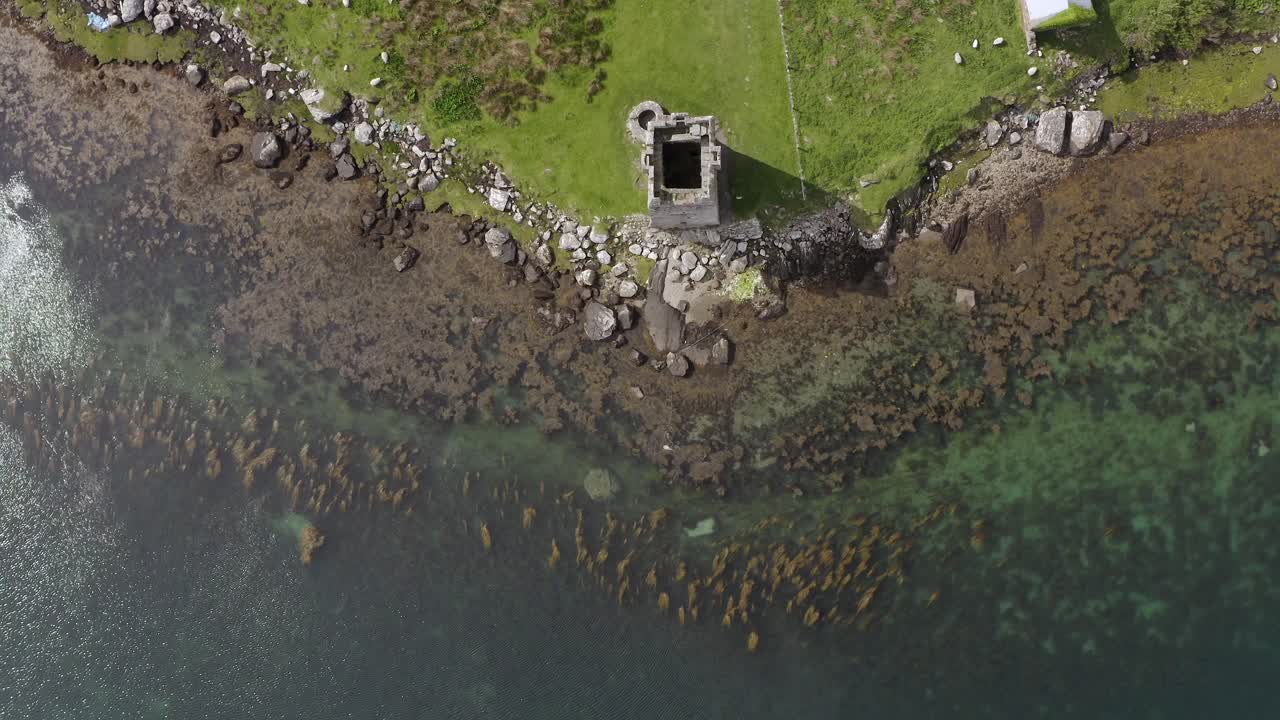 Static bird's eye view aerial of towerhouse and coastline in ireland, achill island.