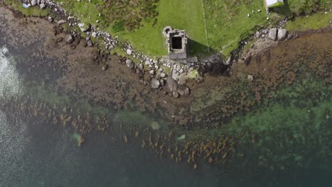 static bird's eye view aerial of towerhouse and coastline in ireland, achill island.