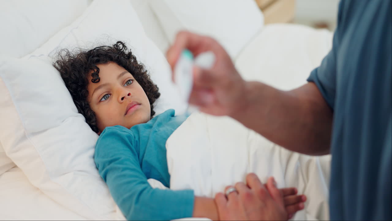 Father, thermometer and sick child in bed