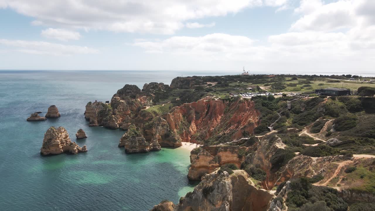 Drone captures stunning coastline, dramatic limestone cliffs, and turquoise water by Lagos Algarve