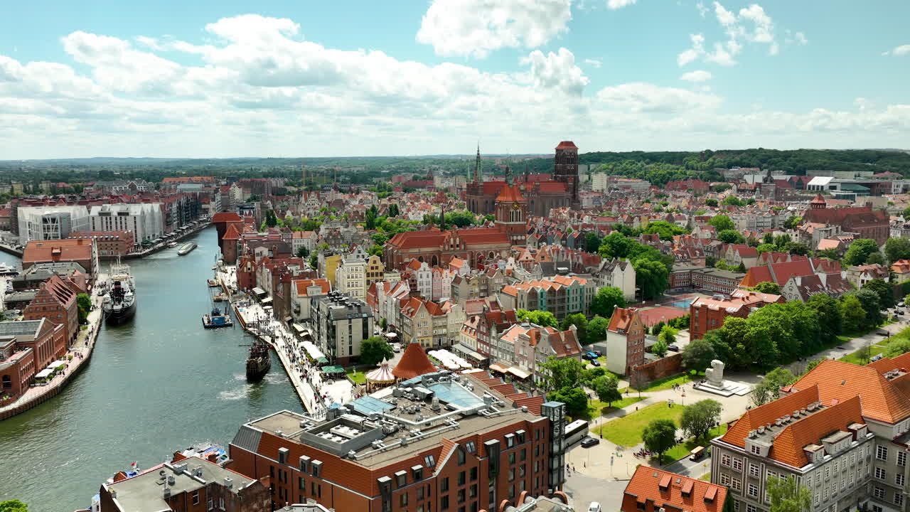 vista aérea del casco antiguo de gdańsk, con edificios históricos y el río motława bajo un cielo azul brillante con nubes