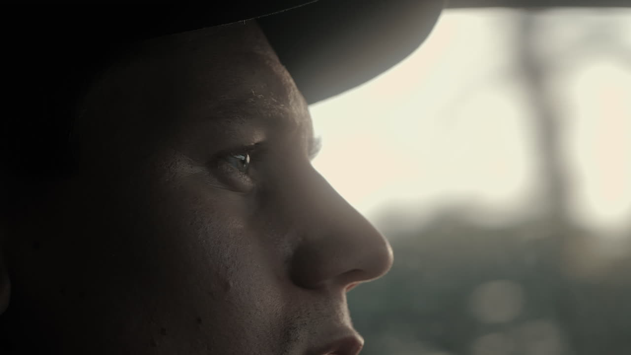 Close Up of a male driving a car in the morning sun going to work. Close Up Face. 4K Slow Motion