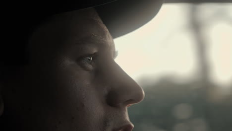 close up of a male driving a car in the morning sun going to work. close up face. 4k slow motion