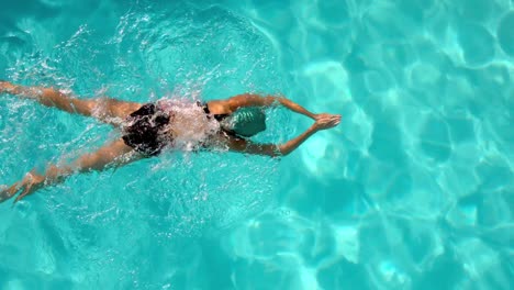 fit female swimmer doing the breast stroke in the swimming pool