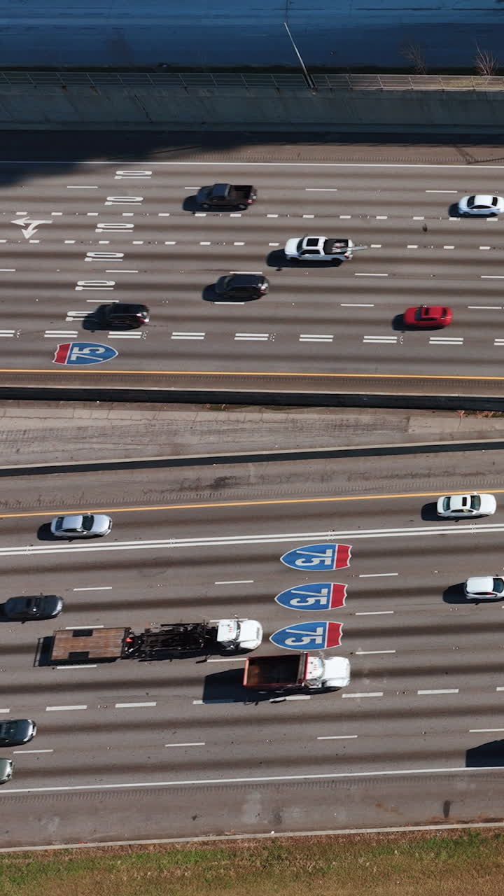 Heavy traffic on wide multi-lane road in Atlanta, Georgia. View from above. Road sign on the asphalt. Busy Interstates 75 road, aerial drone view. Vertical