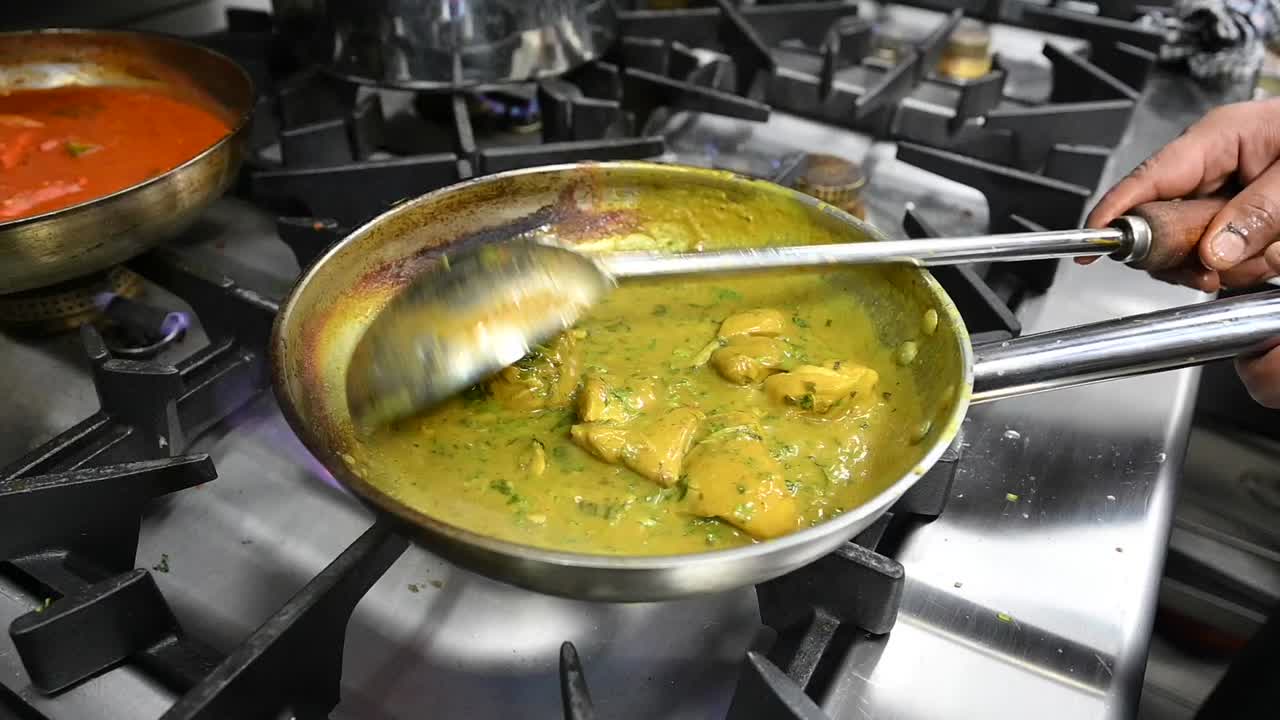 preparación del tradicional corma de pollo de hyderabad en la cocina de un restaurante