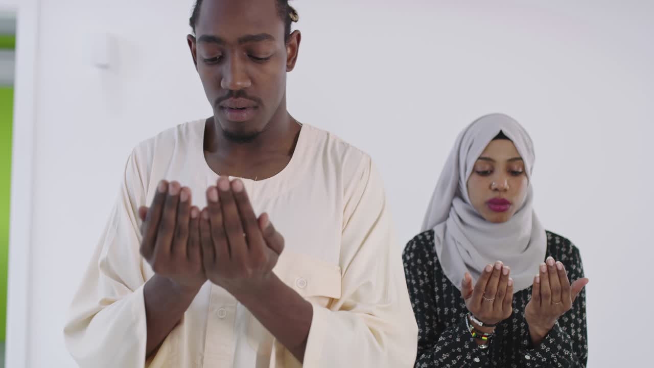 African black muslim couple at home in ramadan Making Traditional Fatiha Prayer To Allah God While Wearing A Traditional Sudan fashion clothes in studio