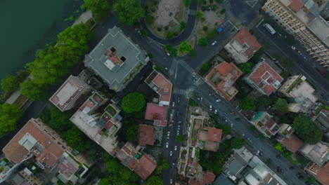 Vista-Panorámica-De-Arriba-Hacia-Abajo-De-Los-Edificios-En-El-Distrito-Urbano.-Revelando-Los-Vehículos-Que-Circulan-Por-El-Puente-Sobre-El-Río-Tíber.-Roma,-Italia