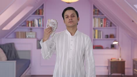 indian man using money as fan in attitude