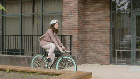 young woman in formal clothes going to work on bicycle