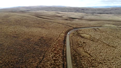 White-car-drives-down-remote-Lake-Onslow-road-in-Central-Otago