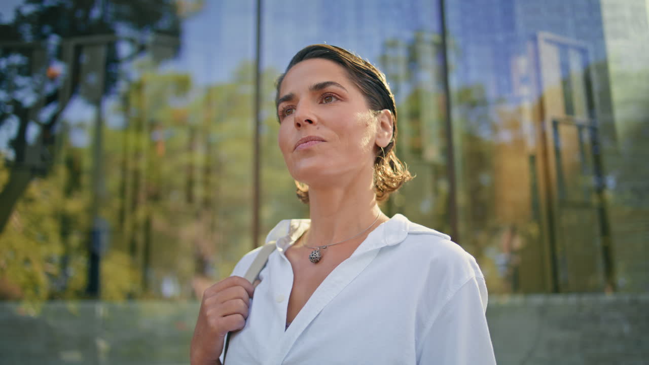 retrato de una mujer de negocios madura posando en la fachada de una oficina de vidrio.