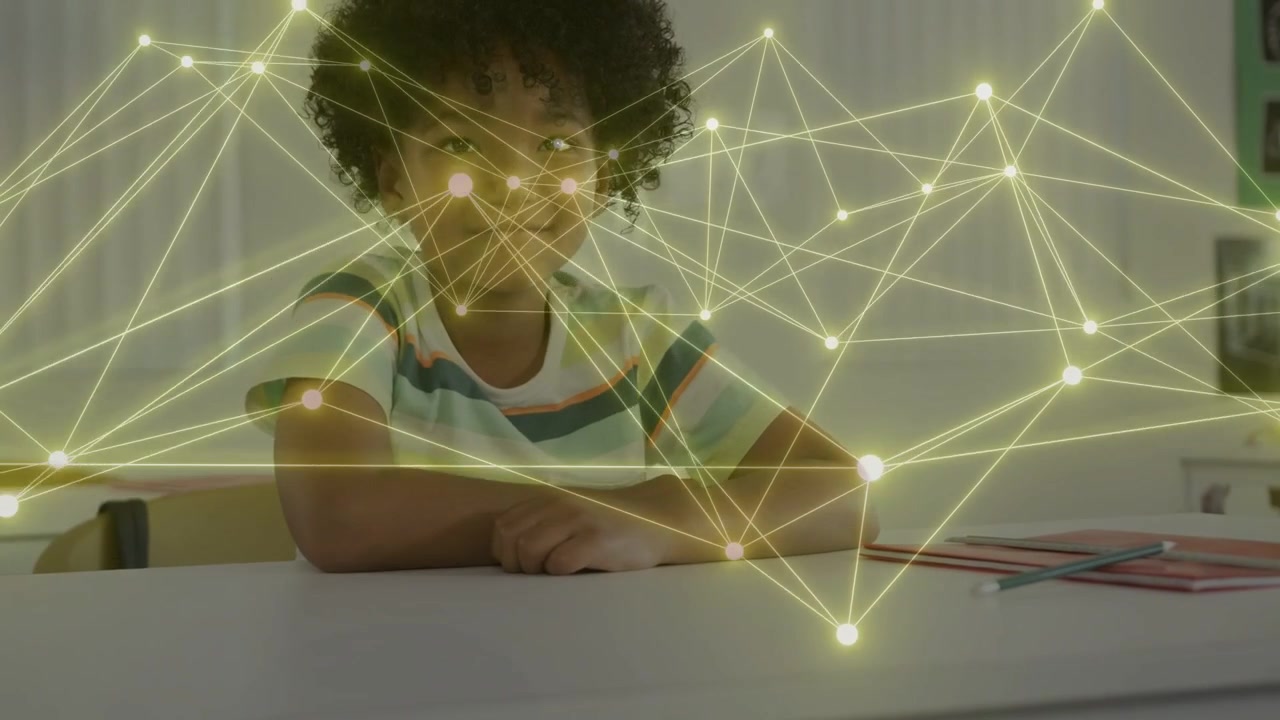 Male student looking at camera, initiating glowing web drifting over desk, visualizing education