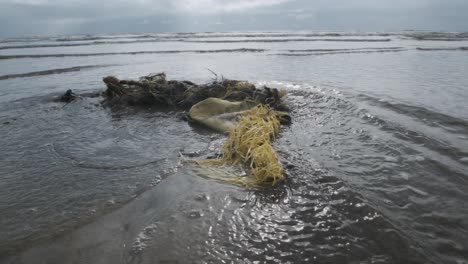 Meerwasser,-Das-Um-Plastikmeeresmüll-Herumfließt,-Müll-Am-Strand-In-Zeitlupe