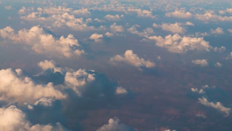 video tomado desde un avión que vuela sobre nubes gruesas y hinchadas después del amanecer