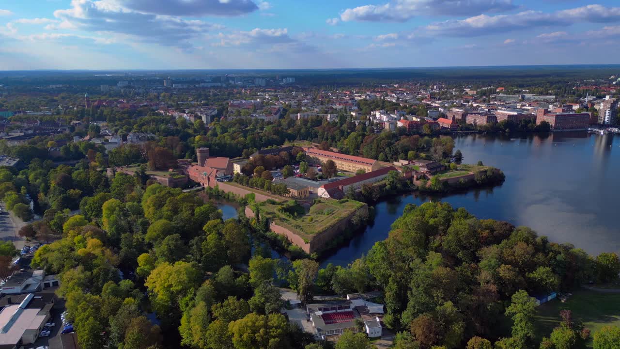 Spandau Citadel, en imponerende renæssancefæstning omgivet af vand, står under en klar himmel. Magisk dronebillede i nedadgående flyvning
