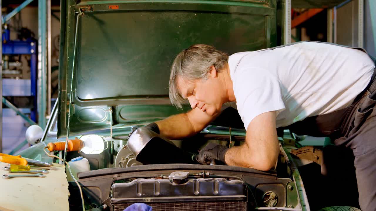 Male mechanic servicing a car 4k