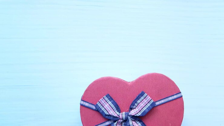 Scatola regalo a forma di cuore in un guanto blu