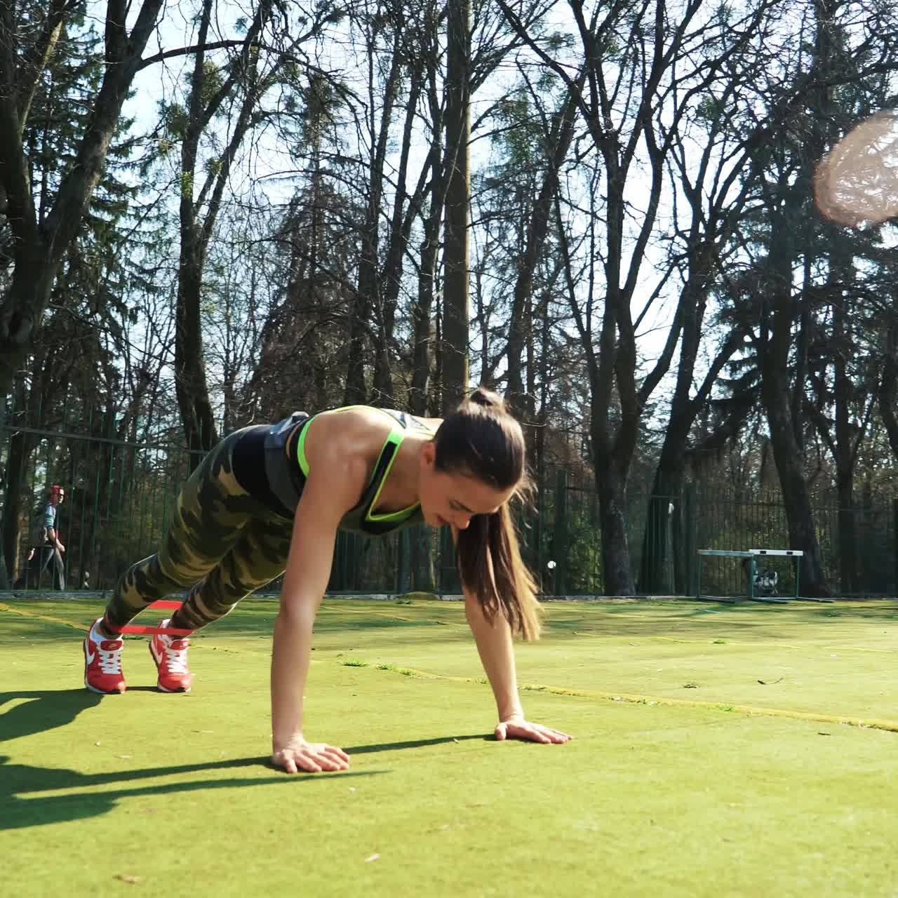 Woman doing exercises outdoors at the stadium. Beautiful young woman working with elastic band. Fitness concept.