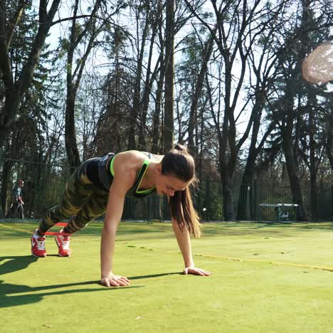 woman doing exercises outdoors at the stadium. beautiful young woman working with elastic band. fitness concept.
