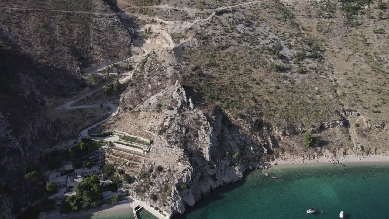 video de drones sobre la playa de zadvarje en la costa de crocia ubicada en la riviera de makarska, se ven barcos