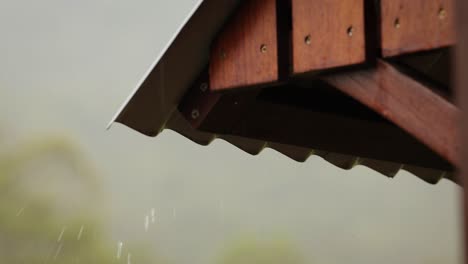 tiro cercano de lluvia suave en un techo de estaño con un marco de madera