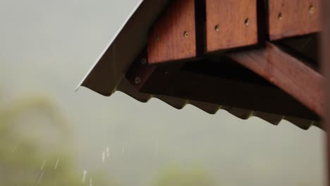 close shot of gentle rain on a tin roof with a timber frame