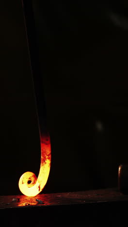 mid-section of blacksmith working on a iron rod