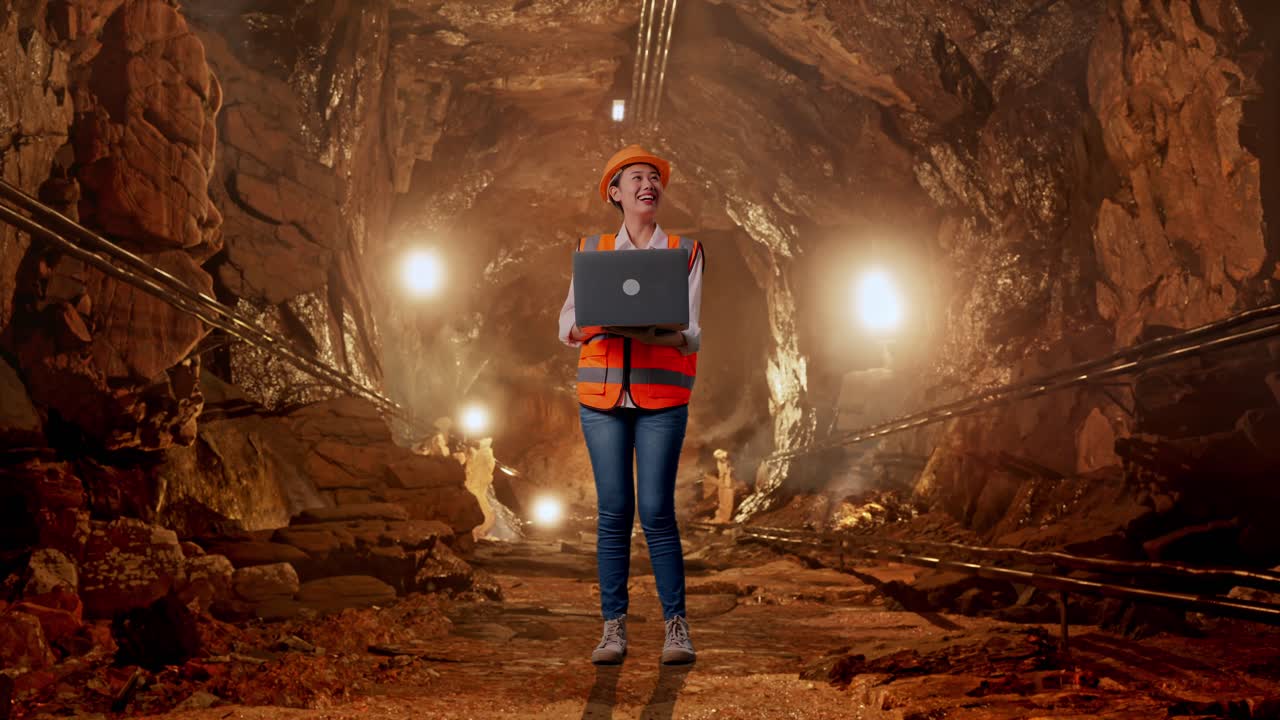 Female Engineer in a Mine Tunnel with a Laptop