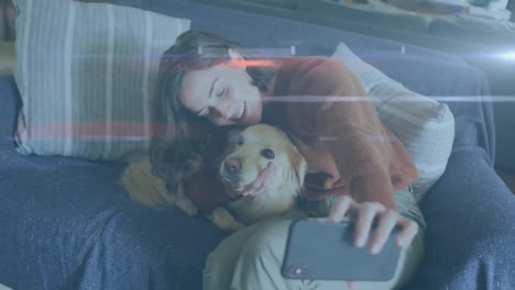 Blaue-Lichtspuren-Vor-Einer-Kaukasischen-Frau,-Die-Ein-Selfie-Mit-Ihrem-Hund-Auf-Der-Couch-Macht