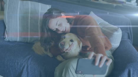rastros de luz azul contra una mujer caucásica hablando de una selfie con su perro en el sofá