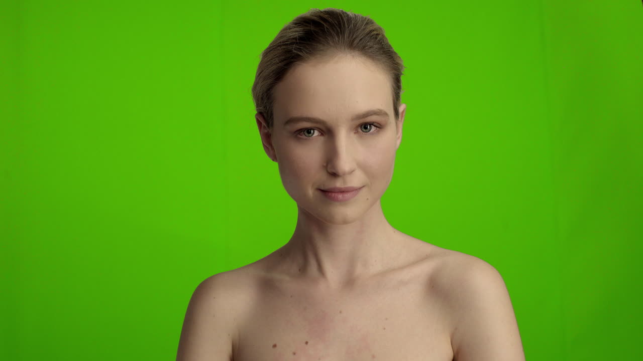 una mujer joven frente a la pantalla verde