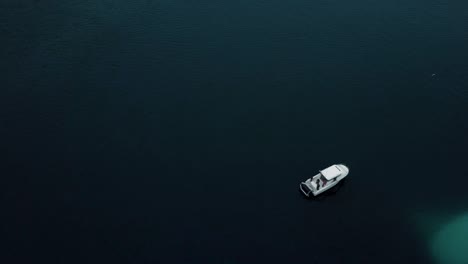 aerial of a motorboat in ice water by a giant ice cap